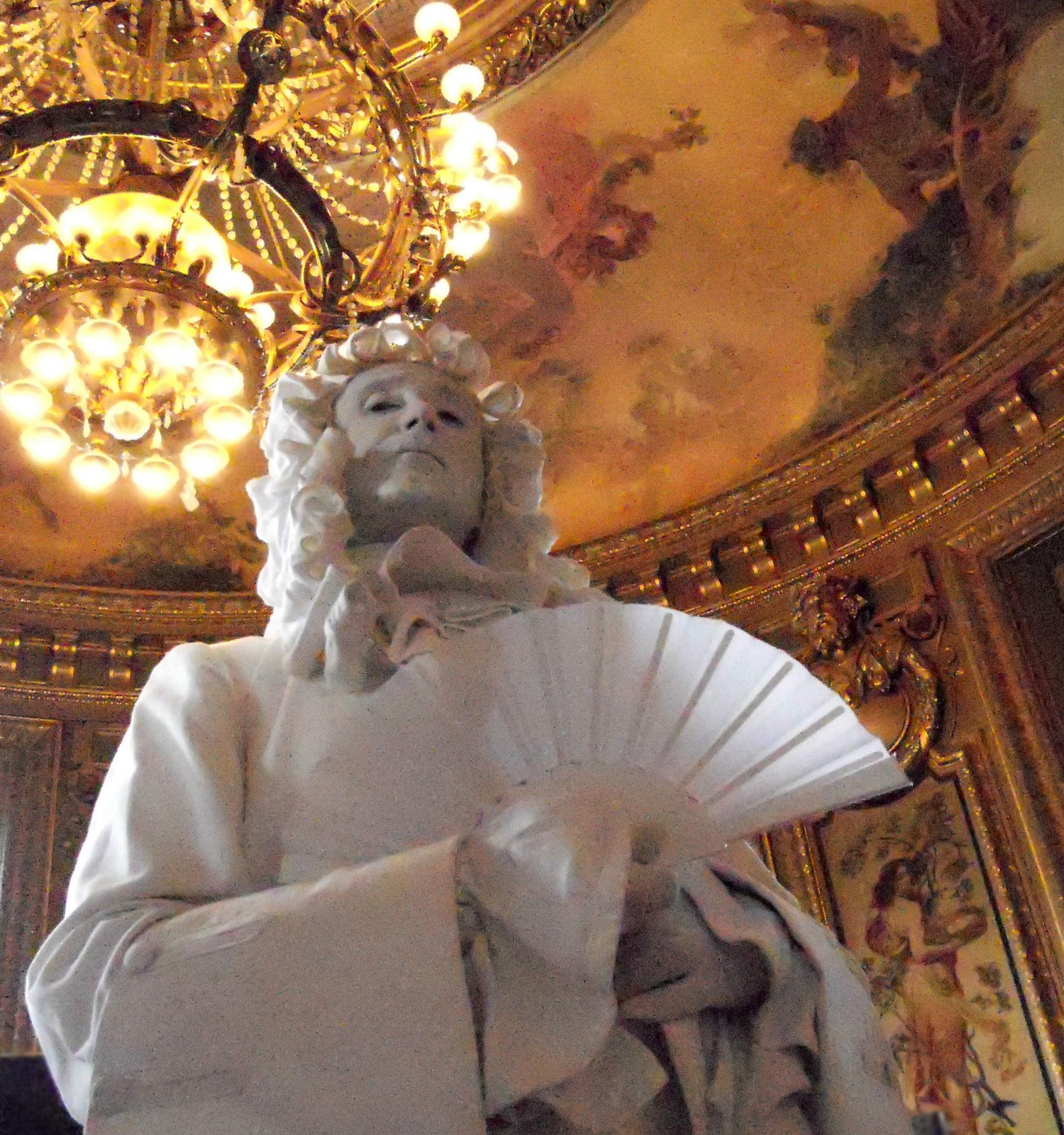 Statua vivente con ventaglio in un teatro storico