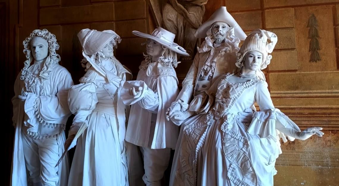 Statue viventi in costume barocco su uno scalone di una dimora storica